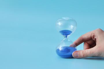 An hourglass in a person's hand, the concept of time and deadlines in life