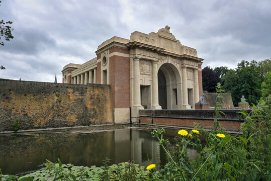 Menin Gate, Ypres, Belgium: War memorial, pond, and cloudy sky.

