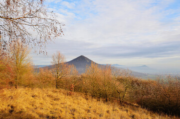 Naklejka premium Rolling Hills Illuminated by Golden Light Under a Tranquil Sky