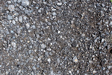 Old worn asphalt covered with crumbs.