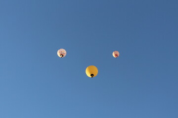 Three hot air balloons are flying against the sky.