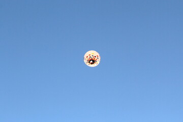 One hot air balloon is flying in the sky.