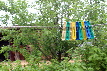 Clothespins hang on a rope.