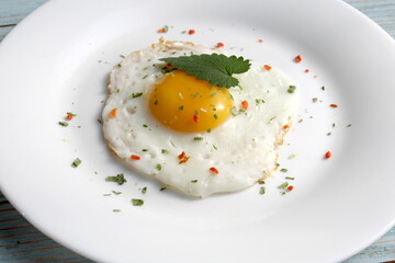 There is a fried egg with a fork on the plate.