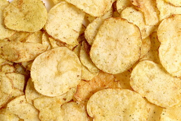 Texture of potato chips stacked on a surface.