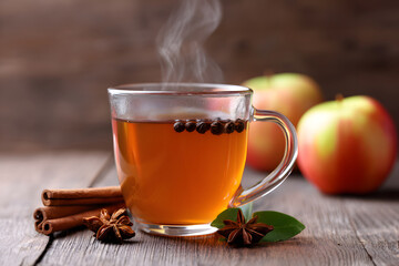 Warm herbal tea with spices and apples on wooden table Generative AI