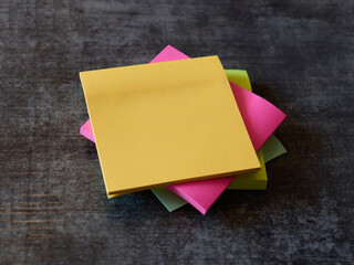 Colorful sticky notes stacked on a wooden table surface