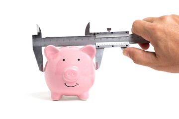 Piggy bank measured with caliper on white background. Concept of growth in finance and business.