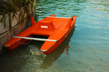 catamaran on water, bright orange catamaran boat on turquoise water on mountain lake, family...