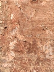 Aged reddish-brown wall texture with crumbling plaster for architectural backgrounds and distressed design elements