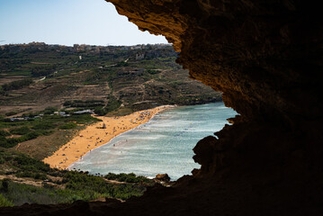 Photo of a beach with golden sand, view from a cave on a mountain