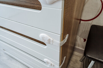 Here we have a detailed closeup view of a beautifully crafted white dresser, which features secure...