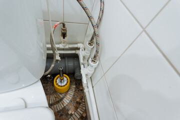 In the bathroom, there is a toilet, which is an essential plumbing fixture. On the floor beside it,...