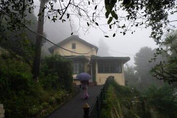 Darjeeling,West Bengal,India-11.08.2023: Woman sari clad devotee passing by an isolated cottage...