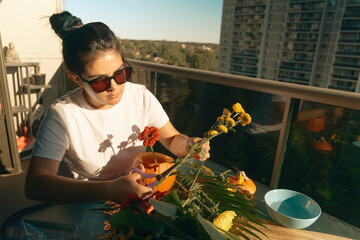 Woman arranging flowers inside a carved pumpkin