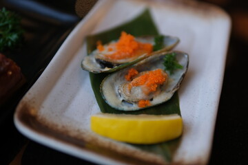 Close-up of fresh oysters with lemon slices and garnishes, gourmet seafood appetizer. Fresh Seafood and Gourmet Dining. High quality 4k footage