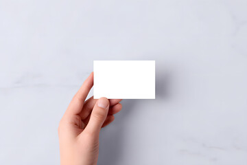 Hand holding blank white business card. Clean and professional mockup on light background. Ideal for branding, identity, and corporate design.