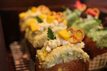 Heart shaped pastries decorated with fresh berries, whipped cream, cocoa dusting, resting on rustic...