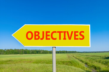 Objectives symbol. Concept word Objectives on beautiful yellow road sign. Beautiful blue sky green grass and forest peaceful nature background. Business objectives concept. Copy space.