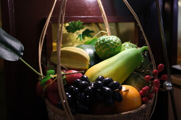 collection of fresh fruits and vegetables in a wooden basket on a table in a modern kitchen...