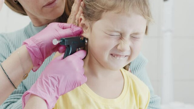 First ear piercing. Preschool girl gets first in life experience of ear piercing in the hospital