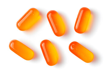 Orange capsules scattered on white surface. Medication, health supplement or vitamin concept. Simple and clean layout.