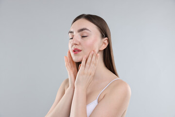 Woman with healthy skin on grey background