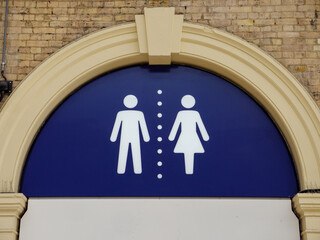 Men's and women's separate gender public toilet stickmen sign outside entrance