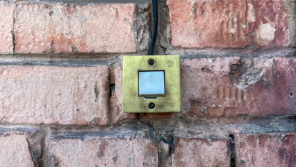 An old light switch with the USSR quality mark on an old brick wall.