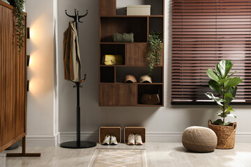 Shelving unit with different accessories and shoes in hallway