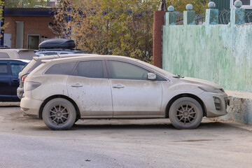 Dust covered cars parked on a city street with faded paintwork, highlighting neglect and urban...