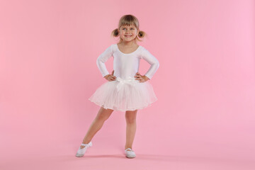 Cute little girl dancing on pink background