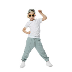 Happy little boy in sunglasses and baseball hat dancing on white background