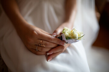 Hands holding white rose on wedding day