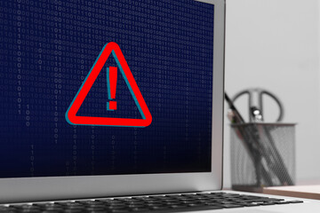 Cyber attack alert notification. Red warning sign and binary code on laptop screen, closeup