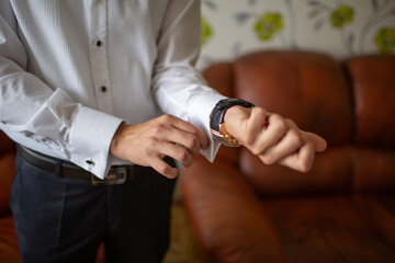 Man fastening cufflink on dress shirt