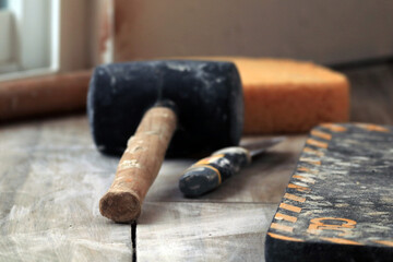 A tool lying on the floor. Mallet, spatula and sponge