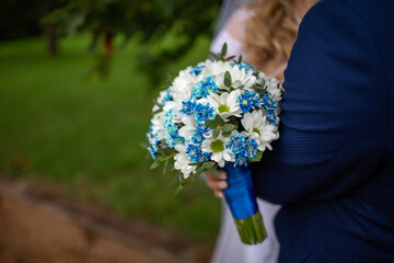 Bride holding blue and white bouquet