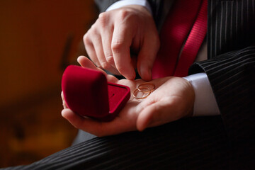 Man holding wedding rings in red box
