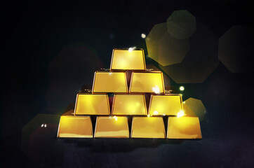 Stacked shiny gold bars on black background. Space for text