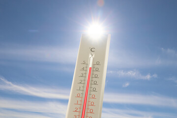 Extremely high temperature on thermometer against blue sky on sunny day. Summer weather