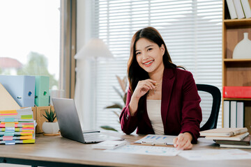 Young Asian woman doing financial accounting and taxes for a company Organizing account analysis reports Investment information Financial and tax system concepts
