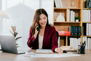 Asian businesswoman chatting on smartphone, auditor, document search, report, analysis, tax, accounting, document, data, contract, agreement at work.
