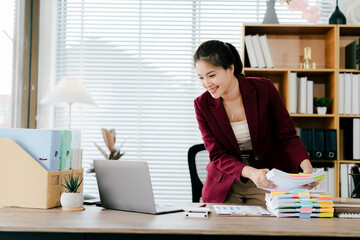 Female employee working with pile of documents to search for information and check documents on...