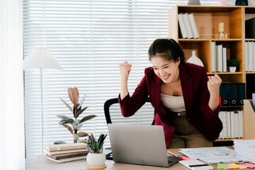 Asian woman is excited about her victory in the office. Female employees are very happy about their completed project.