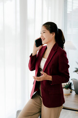 Asian businesswoman chatting on smartphone, auditor, document search, report, analysis, tax, accounting, document, data, contract, agreement at work.