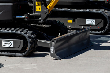 ndustrial excavator rubber tracks and front blade on concrete surface modern construction equipment...