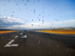 A road with cars on it and raindrops on the windshield