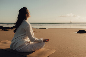 Asian woman in white clothes practice yoga for meditation and relaxation for healthy near seaside....
