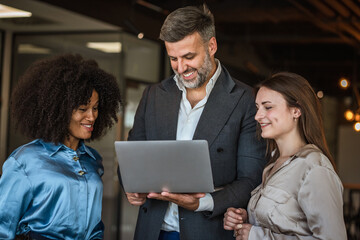 Helpful male boss mentor explain new project to young females workers